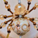 Fantasy-inspired gold and cream spider ornament made with crystal beads and wrapped wire legs